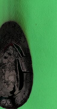 Burning Green Paper Curls on Black Background. Green paper smolders and burns against black background its edges curling as smoke rises. Sheet gradually chars and darkens in stark isolated view.