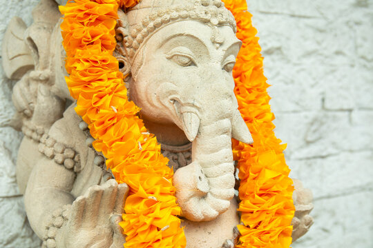 Lord Ganesha. Lord Ganesha statue decorated with vibrant orange flowers