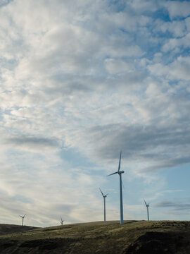 Wind turbines generating clean energy on a grassy hillside
