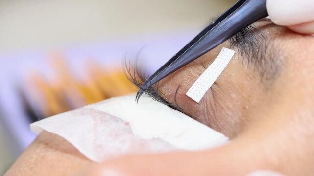 Eyelash extension process in a professional beauty salon, close-up view
