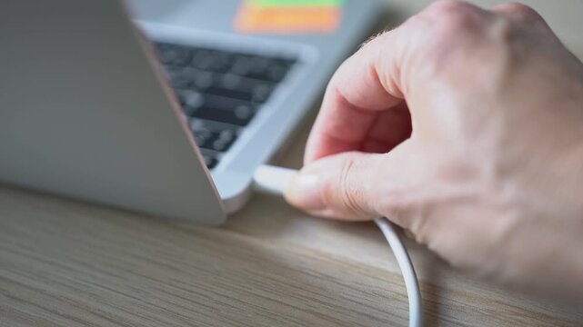 Connecting a USB Type-C cable to a laptop port to charge the battery.
