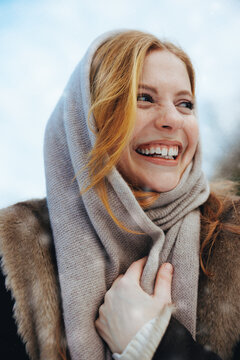 Scarf-holding woman poses for winter fashion outdoors