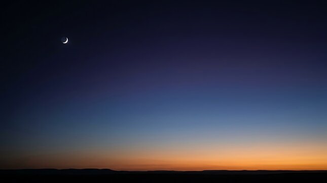Tiny crescent moon appearing in the clear evening sky during twilight with astronomy celestial atmosphere landscape