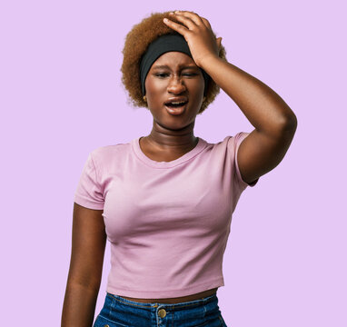Young african american woman wearing pink clothes, hand on head after a mistake and error, forgot an important memory in studio