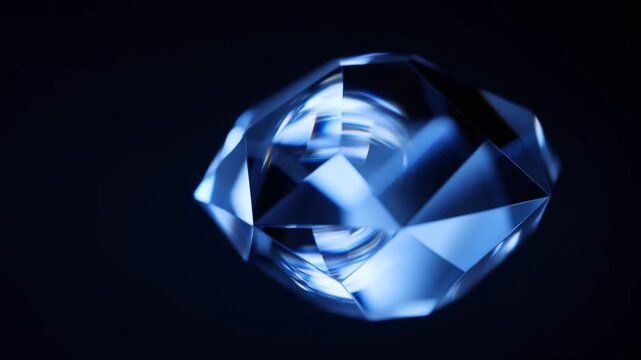 Faceted blue crystal gem glowing with light reflections on dark background