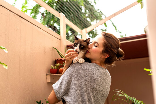 Woman embraces cat lovingly outdoors