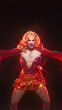 Fabulous drag queen dancing in a sparkling red costume