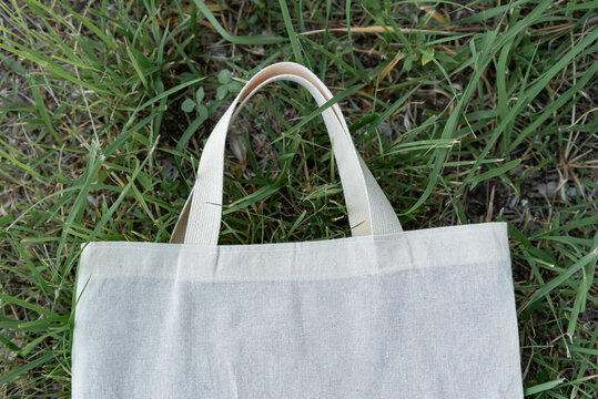 Blank Canvas Tote Bag on Green Grass Representing Sustainable Living
