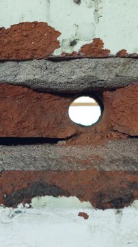 Vertical video: Camera starting at doorway moving along brick alley, revealing textures for study