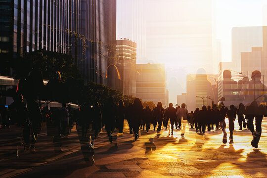 Crowd of anonymous people walking on sunset in the city streets