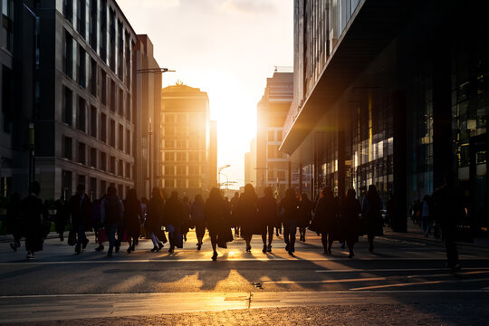 Crowd of anonymous people walking on sunset in the city streets