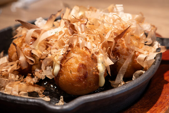 Japanese takoyaki octopus balls served on a sizzling skillet