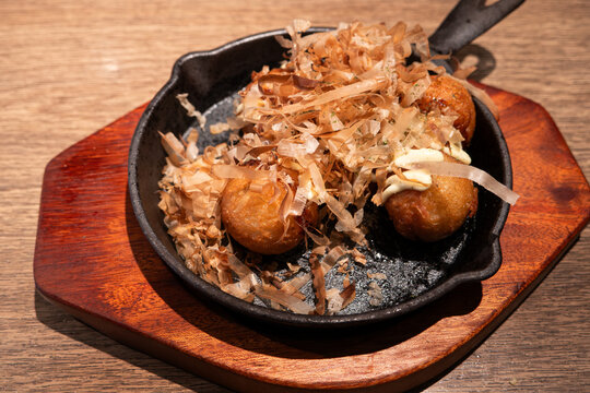 Japanese takoyaki octopus balls served on a sizzling skillet
