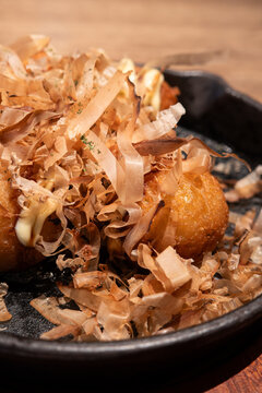 Japanese takoyaki octopus balls served on a sizzling skillet