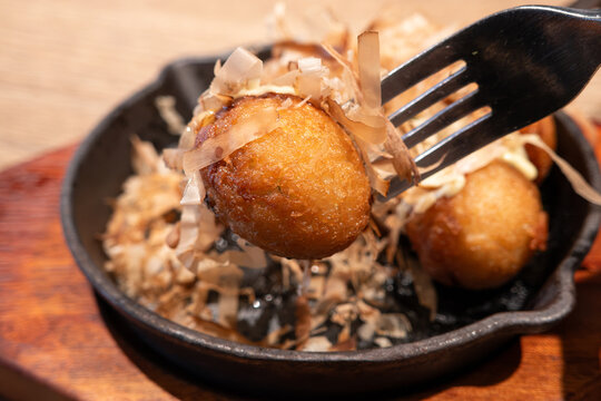 Japanese takoyaki octopus balls served on a sizzling skillet