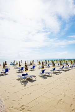 Beach chairs and umbrellas on sandy Follonica beach in Tuscany Italy