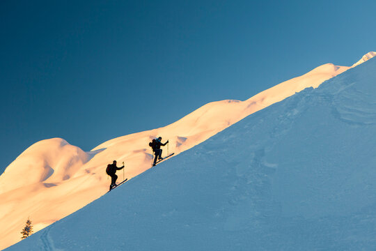 Backcountry skiers ascending snowy mountain slope