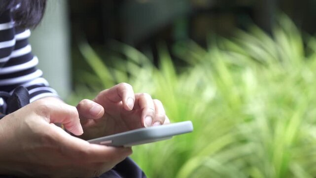 Woman using phone to send text messages or reply to business emails with clients during weekend leisure time at modern cafe.