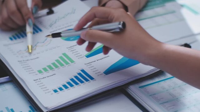 Two female accountants counting on calculator income for tax form completion hands close-up. Business and audit concept