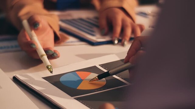 Two female accountants counting on calculator income for tax form completion hands close-up. Business and audit concept