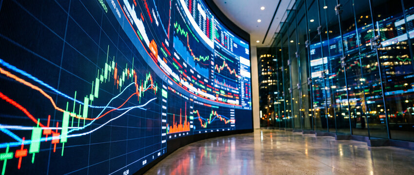 Close-up digital wall,  computer screen, with stock market data and charts in a lobby. Investment company, broker, bank, stock exchange, building, information.