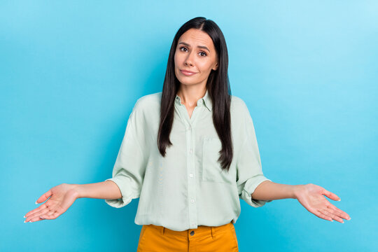 Photo of young attractive lady shrug shoulders puzzled trouble misunderstanding  isolated over blue color background