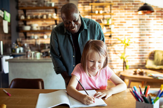 Man helping girl with homework at kitchen table