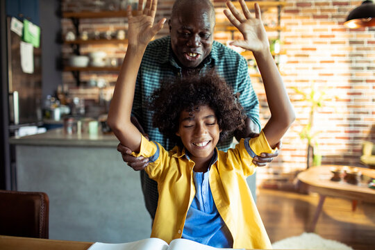 Boy celebrates homework success with supportive man at home
