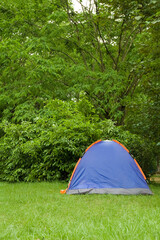 Camping tent in a grassy field with trees © henvryfo