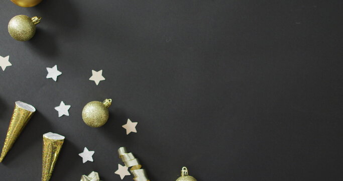 Baubles and stars on black background at new year's eve