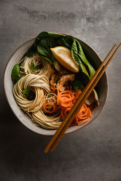 Asian noodle bowl with bok choy, spiralled carrots, fresh mint, lemon