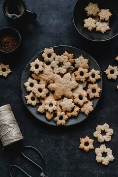 Christmas ginger cookies on black plate with coffee and baking tools