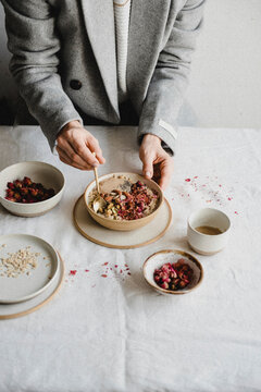 Porridge with pistachios, rose petals, chia seeds, and tahini paste