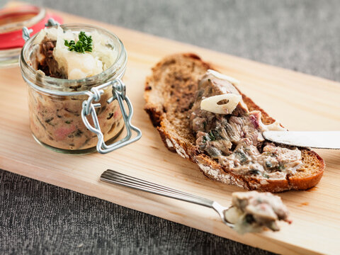Chicken liver pate spread on bread slice on wooden board