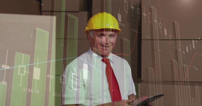 Holding tablet site manager wearing yellow hard hat, red tie presenting financial charts in office