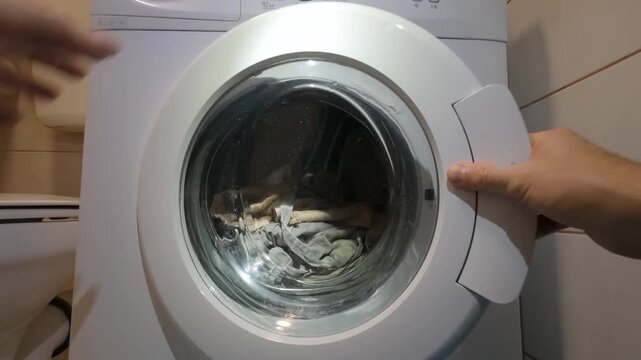 Hand Opening Washing Machine Door With Laundry Inside