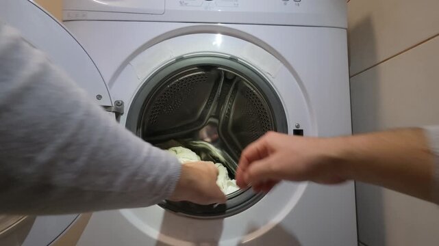 Man Hands Unloading Clean Laundry From Washing Machine