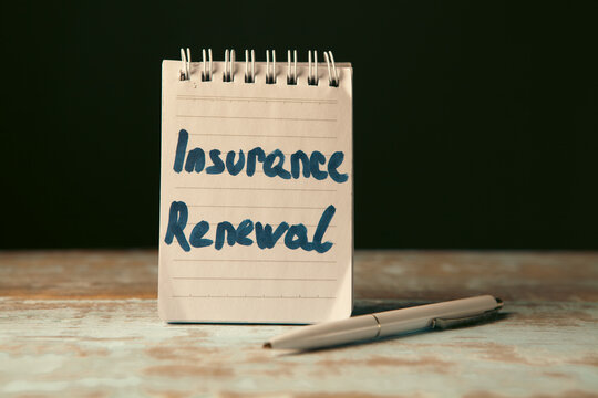Notebook with text insurance renewal  on wooden background