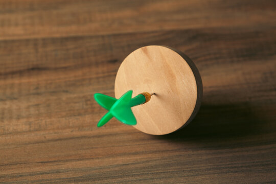 Wooden target with green arrow on wooden background, close-up
