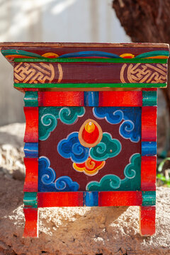 Painted wooden table with cloud motifs and a flaming jewel design at Yuru Monastery, Ladakh, Lamayuru, India