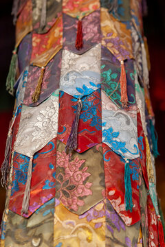 Colorful brocade silk banners with tassels on a pillar at Thiksey monastery, Ladakh, Thiksey, India