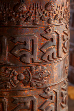 Close up of a copper prayer wheel engraved with Tibetan mantra letters, Ladakh, Leh, India