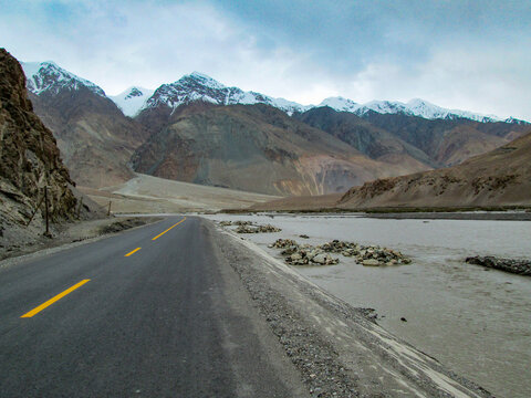 Scenic road through mountainous area with snow-capped peaks in the distance