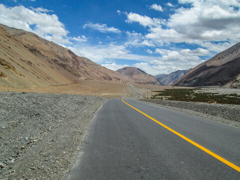 A long road stretching through mountainous terrain under a clear sky