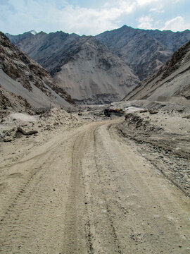 Rugged mountain road with vehicle tracks in a rocky valley