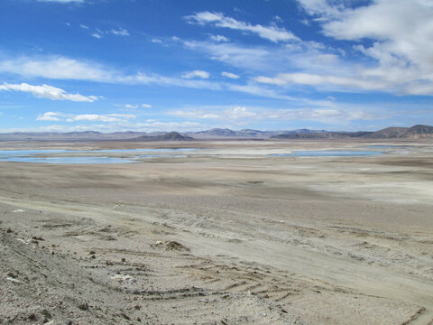 Vast arid landscape with scattered water bodies under a clear sky