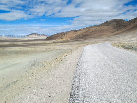 Desert road with mountains and clear sky in the distance