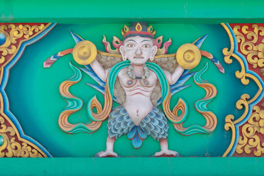 Painted relief of a winged figure holding golden discs on a turquoise Buddhist decoration, Ladakh, Turtuk, India
