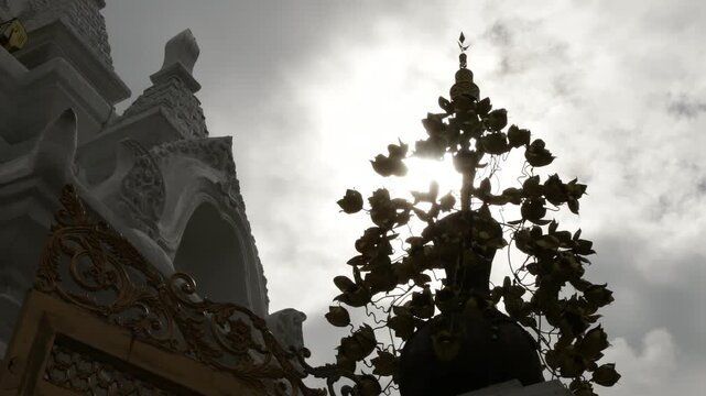 Beautiful Lanna architectural details of the entrance gate and golden gable at Wat Phra That Hariphunchai in Lamphun, Thailand.