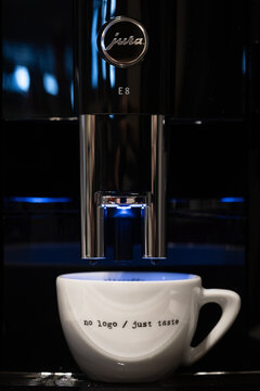 Close-up of a Jura E8 coffee machine ready to dispense coffee into a cup.